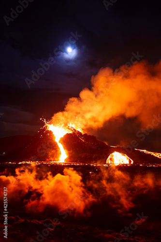 Moon over erupting volcano in Geldingadal Iceland © Arctic Mystic