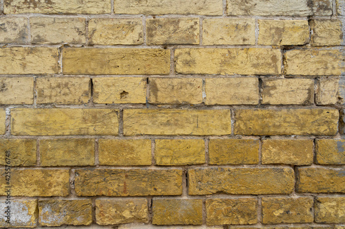 old yellow brick wall     close-up background of the. Ancient Yellow brick wall background.
