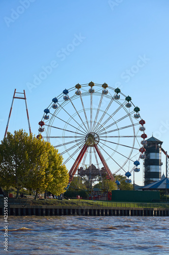 Ferris wheel on the banks of the river, from the river.