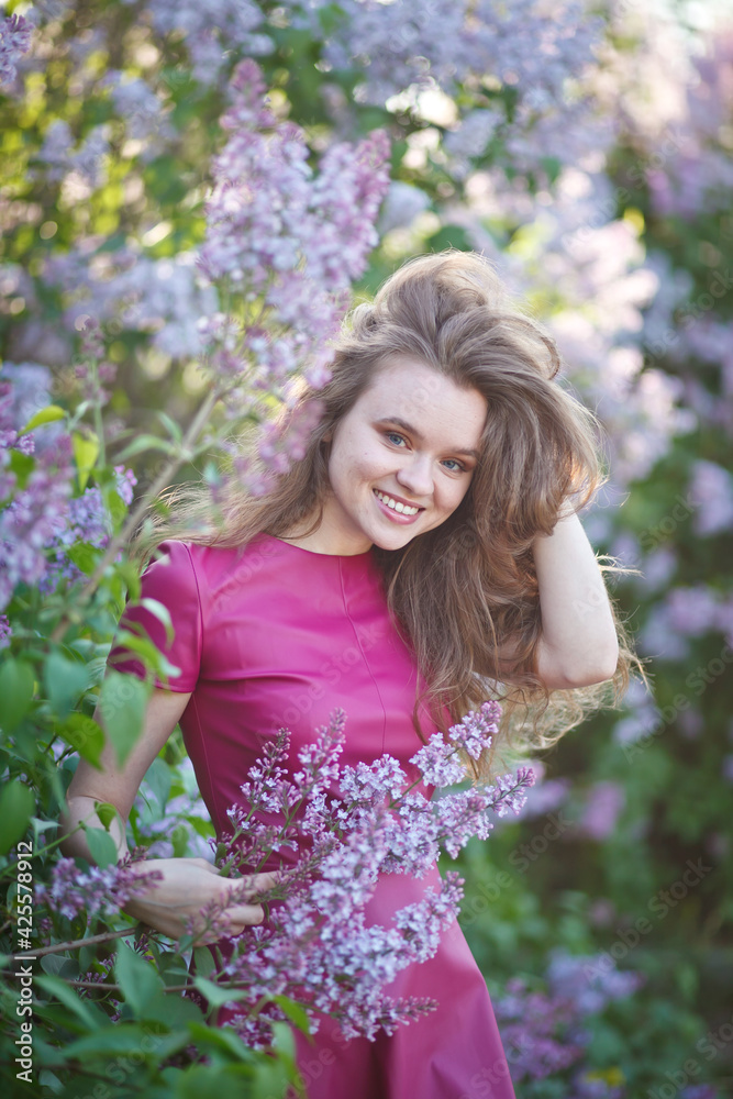 beautiful girl in a short purple dress walks in the lilac garden, leather dress, lilac bloom beautiful girl in a short purple dress walks in the lilac garden, leather dress, lilac bloom