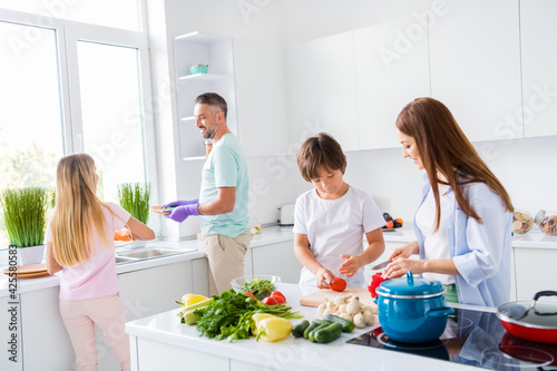 Photo portrait of friendly family cooking meal together cutting salad washing dishes kids helping parents