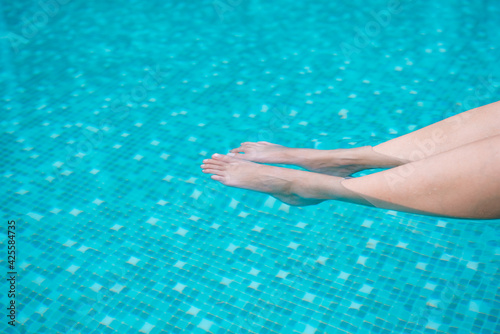 Woman leg in the pool. Vacation time in summer.