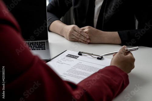 The HR department is reviewing the applicant's resume before giving them an interview with the department manager. The concept of recruiting people to work in the company.