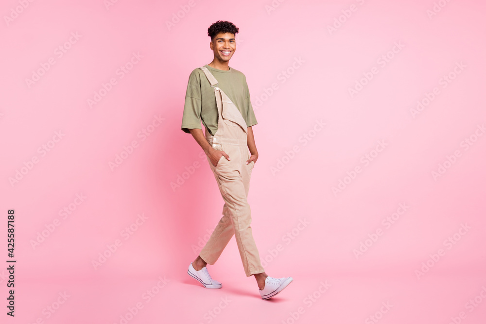 Full length photo portrait of african american guy walking isolated on pastel pink colored background Full length photo portrait of african american guy walking isolated on pastel pink colored background