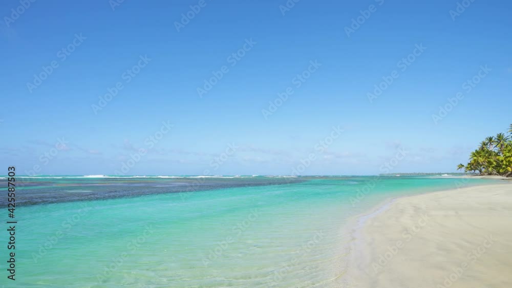 Caribbean coral beach with turquoise seawater waves and white sand. The blue water of the Atlantic Ocean. Caribbean coral beach with turquoise seawater waves and white sand. The blue water of the Atlantic Ocean.