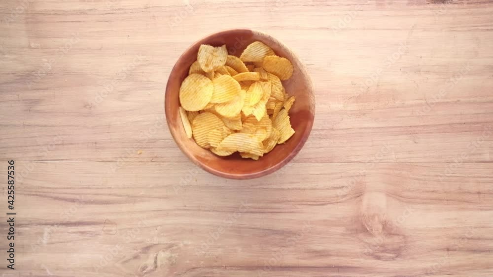 Bowl with tasty potato chips on wooden background . Bowl with tasty potato chips on wooden background .