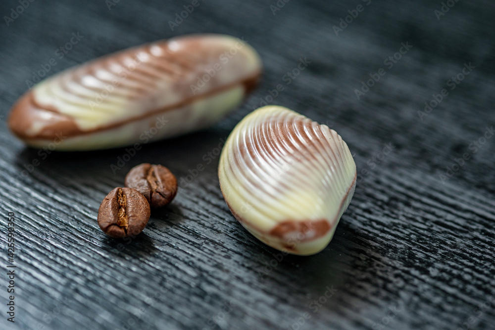 Figures of Belgian chocolate on a dark wooden background close-up.