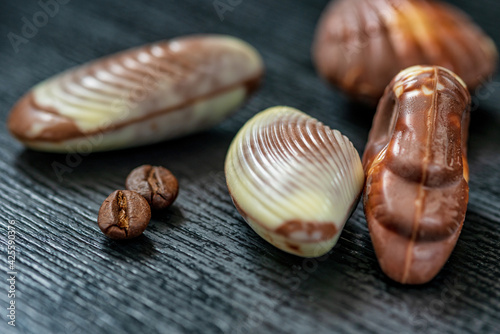 Figures of Belgian chocolate on a dark wooden background close-up.