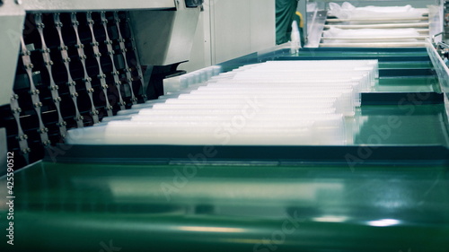 Factory worker wrapping many plastic cups