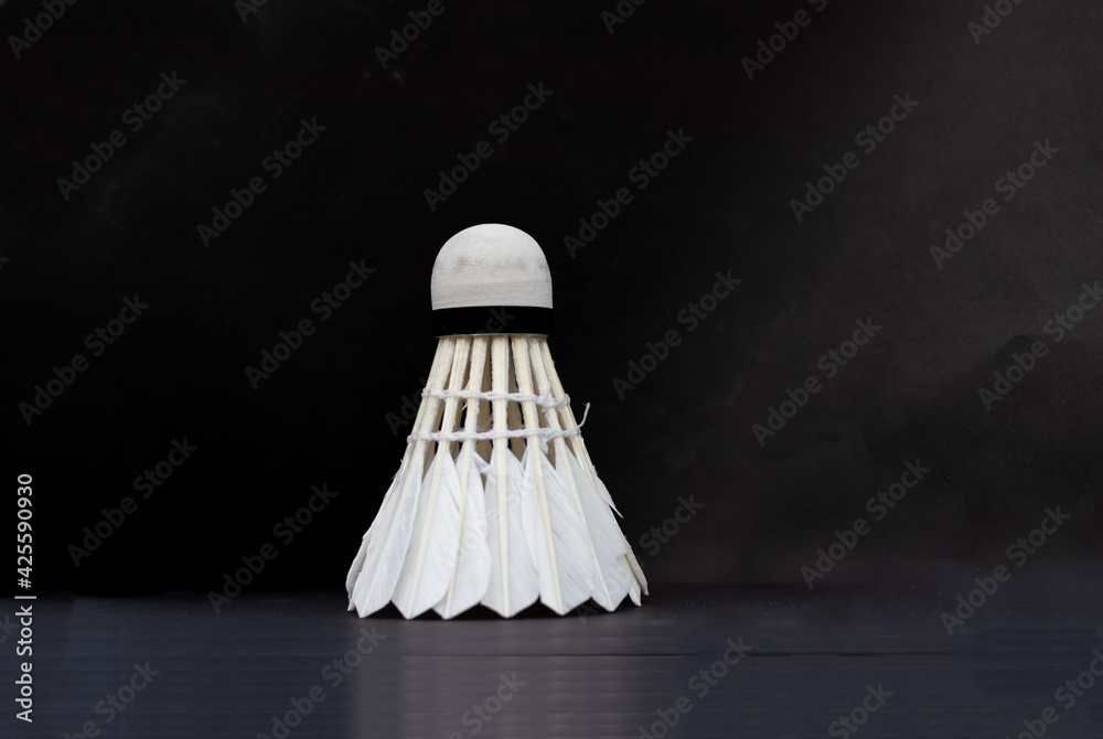White badminton feather shuttlecock on Selective focus over black background White badminton feather shuttlecock on Selective focus over black background