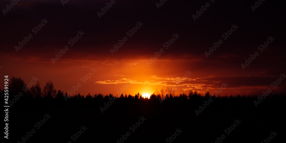 Obraz premium Beautiful clouds over the springtime scenery during the sunrise. Dramatic, colorful look. Rural landscape of Northern Europe.