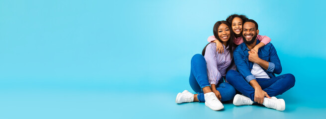 African American man, woman and girl sitting on floor