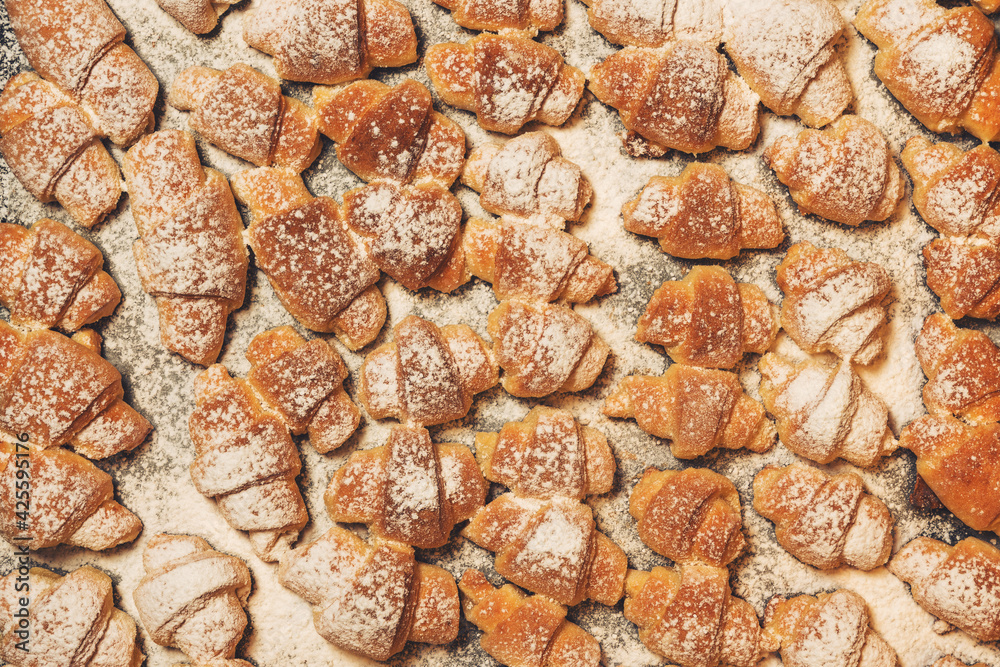 Homemade cakes, on a baking sheet fresh baked in the oven bagels made of cottage cheese dough sprinkled with powdered sugar Homemade cakes, on a baking sheet fresh baked in the oven bagels made of cottage cheese dough sprinkled with powdered sugar