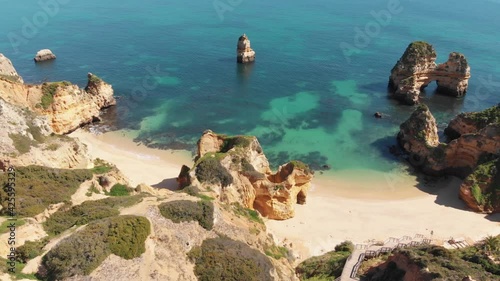 Seclude sand beaches along the Atlantic, Lagos, Algarve. Cliffs and rock formations. High angle orbiting shot