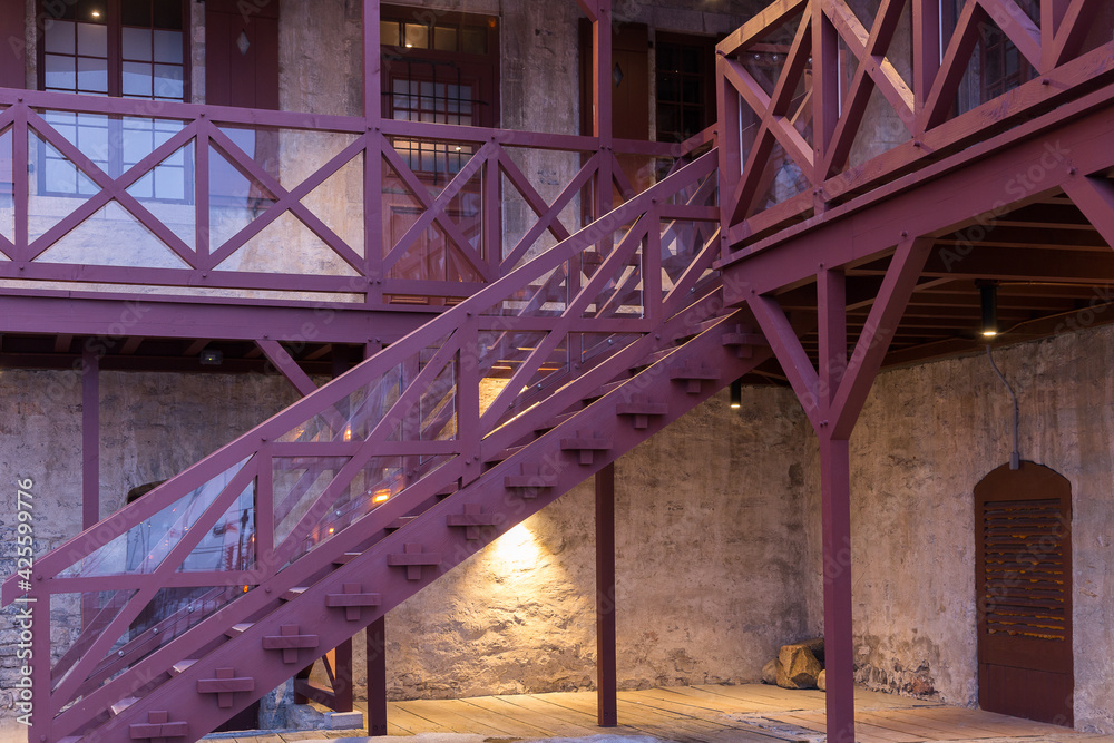 Detail of basement entrance, staircase and balconies of a patrimonial building in the Petit-Champlain area of old town seen during an early spring morning, Quebec City, Quebec, Canada