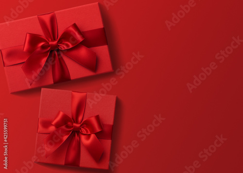 Two red gift boxes on red background flat lay, present box top view 