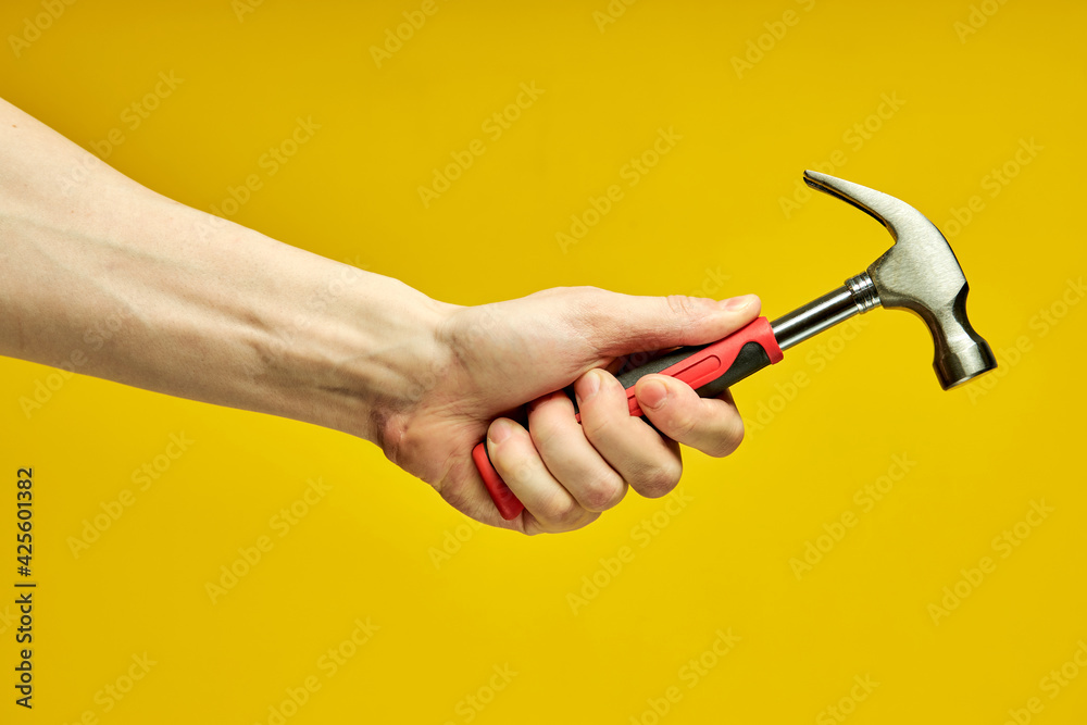 close-up hammer with rubberized handle in cropped male hands close-up hammer with rubberized handle in cropped male hands