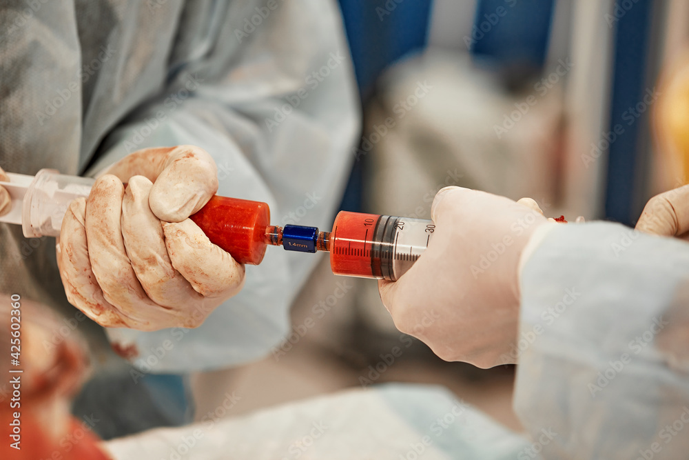 cosmetic liposuction surgery in actual operating room setting showing surgeon hands and cannula cosmetic liposuction surgery in actual operating room setting showing surgeon hands and cannula