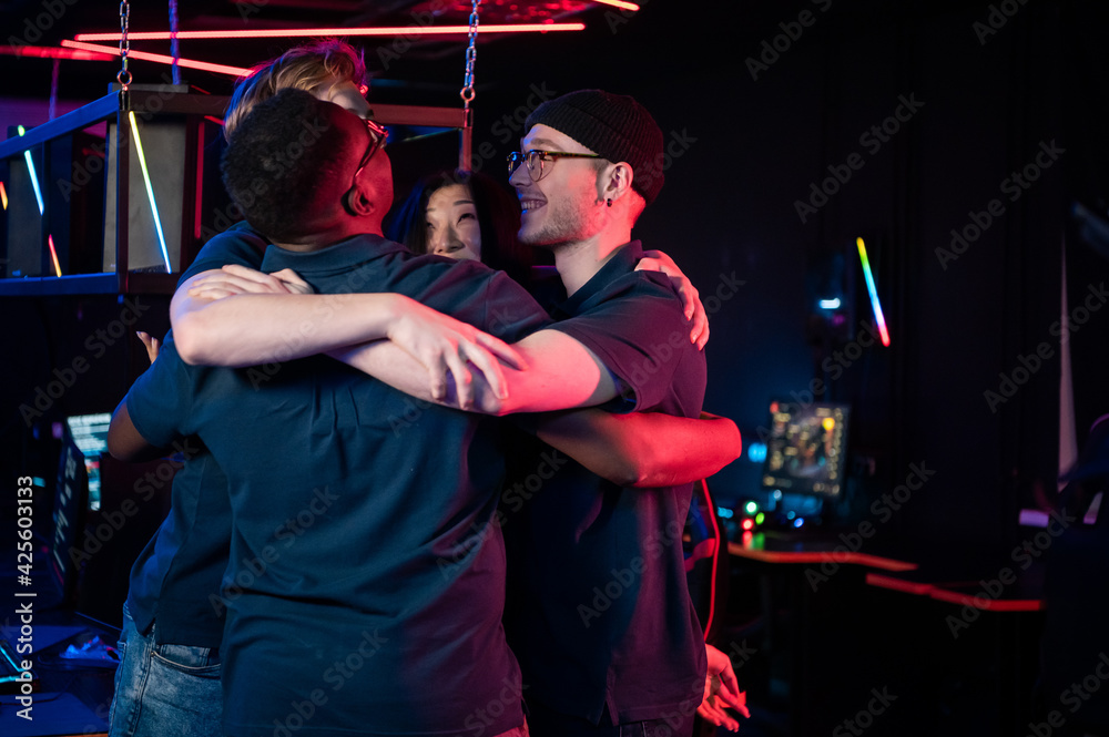 Fototapeta premium Multi-racial team of esports players tune in to the game and embrace for team spirit boost