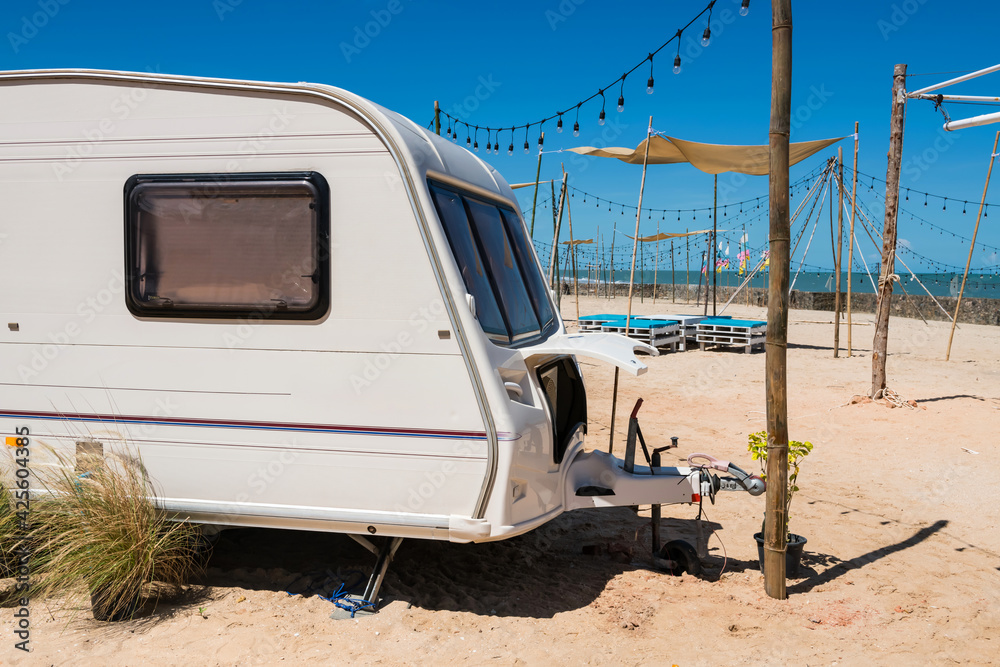 Camper RV car on white beach in summer at Cha-Am