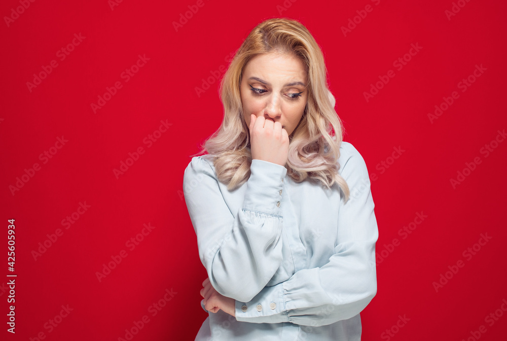 Worried young woman hold her hand on mouth and looking down, isolated on white background Worried young woman hold her hand on mouth and looking down, isolated on white background