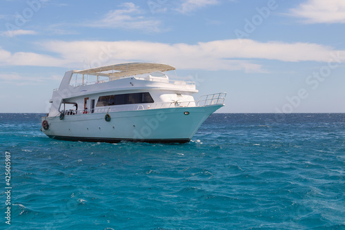 White motor boat against the background of the blue sea and blue sky with clouds, walks in the Red Sea, diving and snorkeling in the open sea © tatiana
