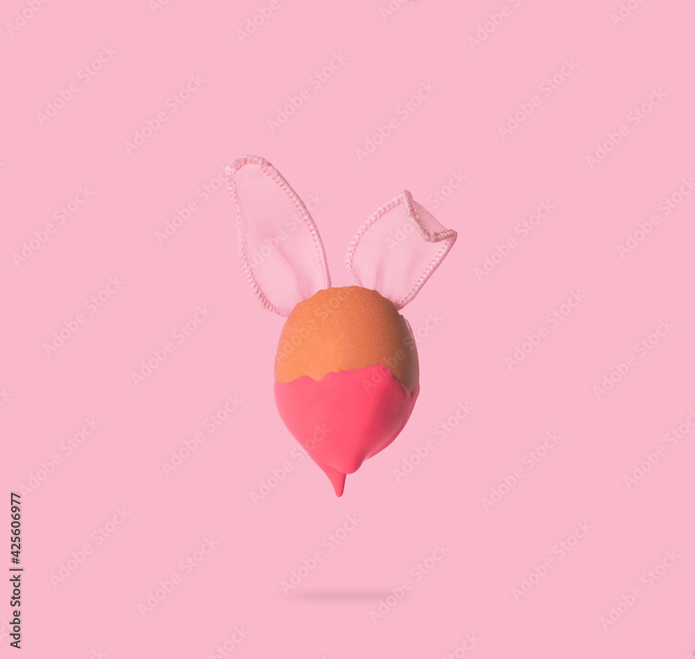 2021 Easter unique concept with bunny rabbit ears on pink background. Creative still life composition.