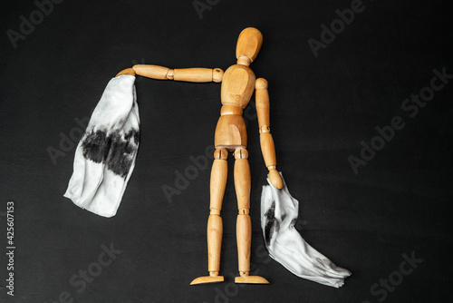 Wooden man holds dirty rags after cleaning. Cleaning concept