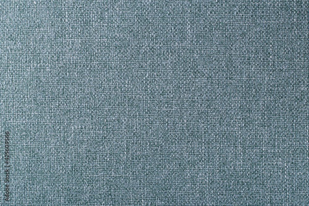 the surface of a dense turquoise upholstery fabric with a linen texture, background the surface of a dense turquoise upholstery fabric with a linen texture, background