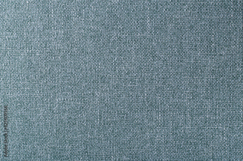 the surface of a dense turquoise upholstery fabric with a linen texture, background