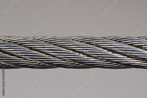 Beautiful isolated macro view of steel wire rope on solid gray background. Metal rope fence, edging of public transport stop near Stephens Green Green Park, Dublin, Ireland. Soft and selective focus