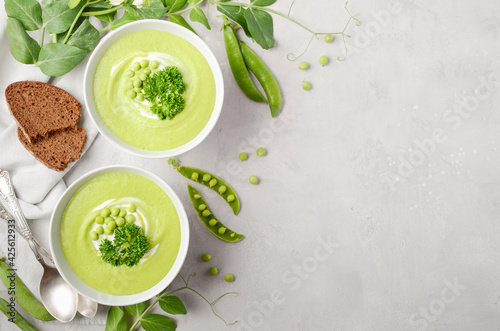 Green pea soup in a bowls on gray concrete or stone background Top view Flat lay Copy space