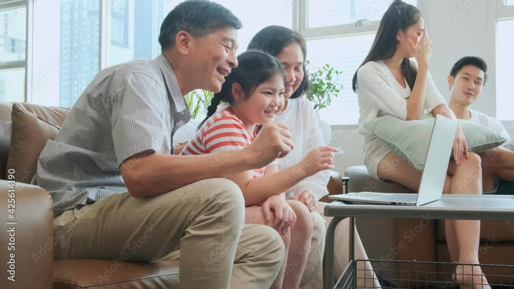 Grand mother grandfather teach little child granddaughter using laptop sit on sofa, happy relation bonding generation asian family spend time online playing with laptop together at home Grand mother grandfather teach little child granddaughter using laptop sit on sofa, happy relation bonding generation asian family spend time online playing with laptop together at home