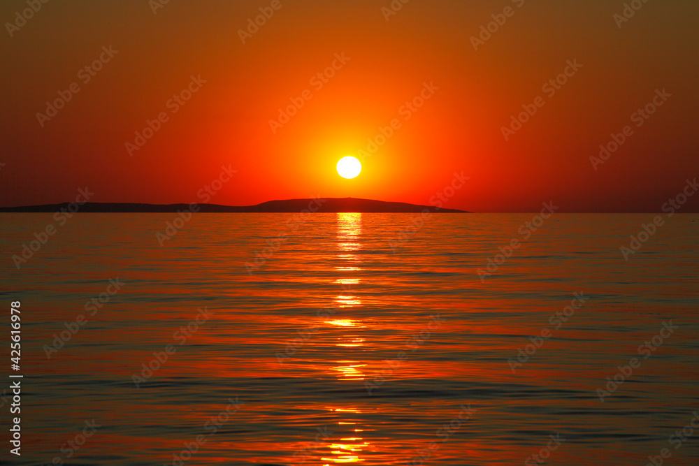 Amazing sunset on the sea horizon with orange red light during sun dawn