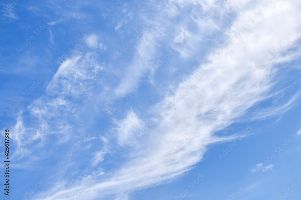 White cirrus rising clouds against clear blue sky. Atmospheric phenomenon. Natural background. Copy space. Selective focus.