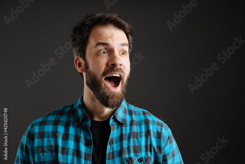 Bearded surprised white man exclaiming and looking aside