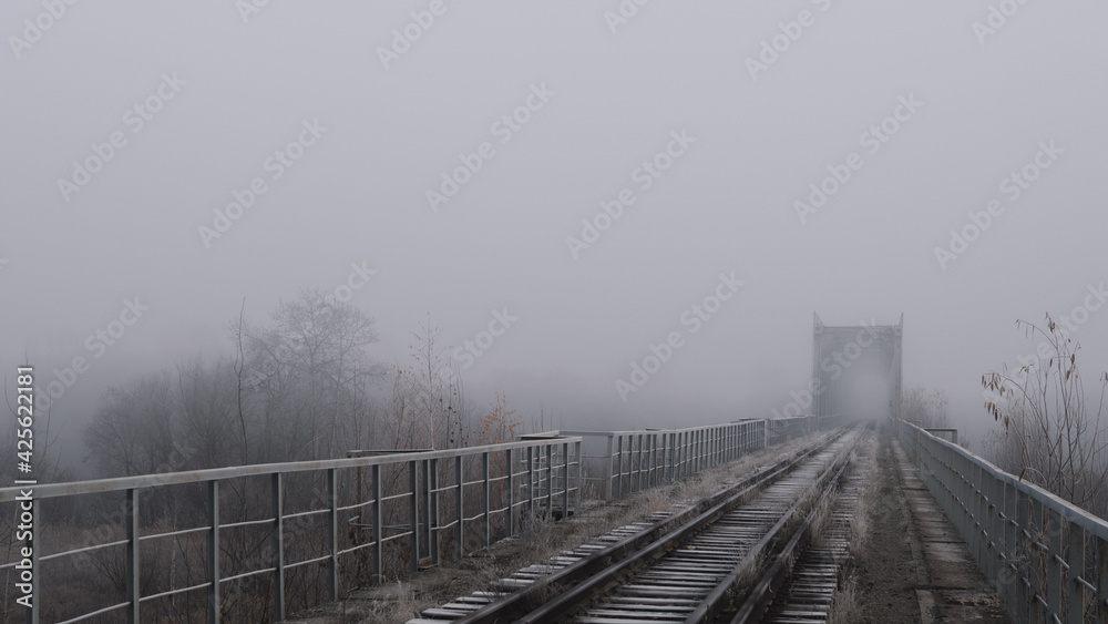 Naklejka premium Heavy fog on the railway bridge, autumn landscape wallpaper