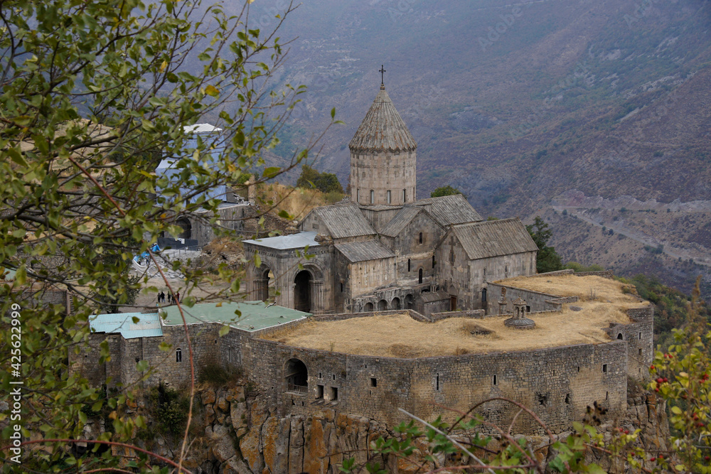 Tatev Monastery with the church of Surp Poghos-Petros (St. Paul and St. Peter) sits on the edge of Vorotan Canyon on a cloudy day in autumn, Armenia