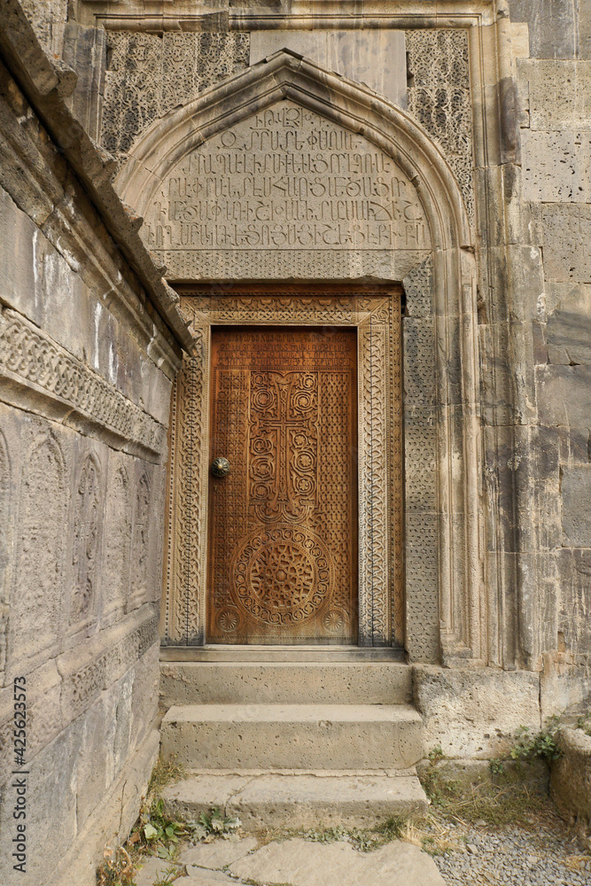 An intricately carved wood door leads into the 9th-century church of Surp Poghos-Petros (St. Paul and St. Peter) at Tatev Monastery, Armenia.