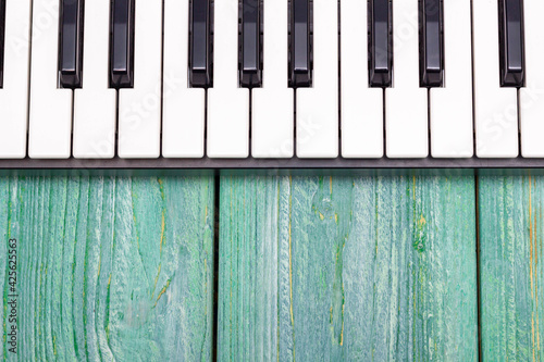 Piano keyboard on a wooden green background