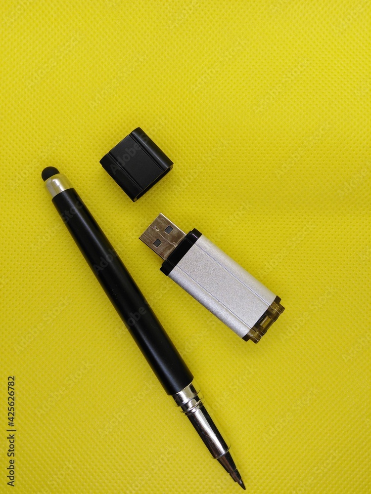 stylus and open flash drive on yellow background stylus and open flash drive on yellow background