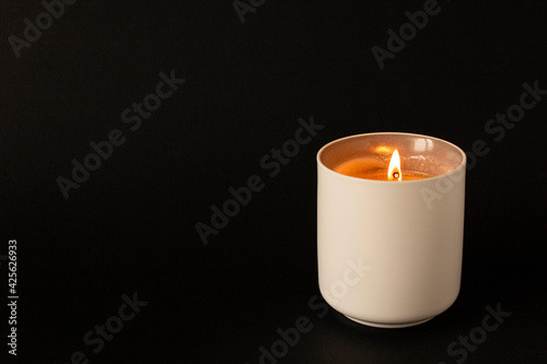 A burning candle on a dark background. Close-up. Selective focus.