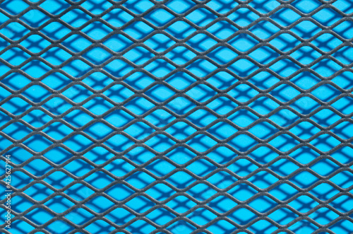 Metal grid of rhombuson blue background close