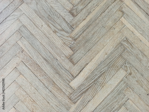 Close up texture of old parquet. Wooden flooring in old building. Plank floor surface. Classic light wood block parquet.
