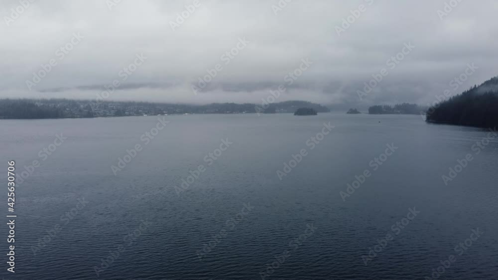 Aerial view of a cloudy bay and surrounding mountains on a rainy day Aerial view of a cloudy bay and surrounding mountains on a rainy day