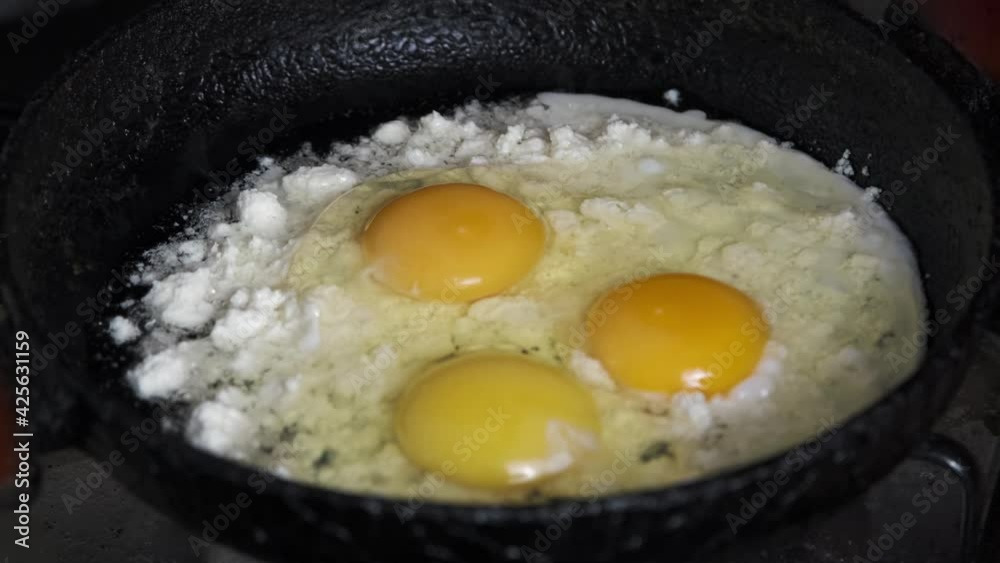Breaking eggs in the pan. While there is cheese in the pan, cracking an egg on it. Breaking eggs in the pan. While there is cheese in the pan, cracking an egg on it.