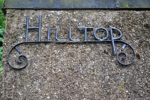 Close Up of Wrought Iron Name Plate on Rough Textured Concrete Wall photo