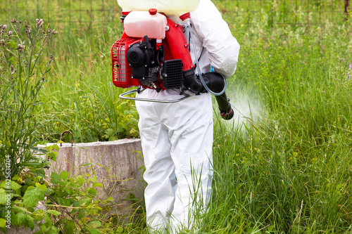 Foto Pest control worker spraying insecticides or pesticides outdoor