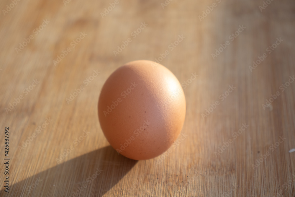 1 chicken egg and several duck eggs. One yellow egg on the table. Chicken egg on the table