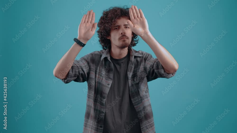 Concentrated young man with acting skills, charismatic. With his hands he mimics a glass wall, invisible, watching his hands. Concentrated young man with acting skills, charismatic. With his hands he mimics a glass wall, invisible, watching his hands.